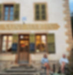 couple sat outside rural French cafe drinking wine