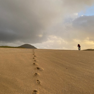 Climbing a sand dune at sunset