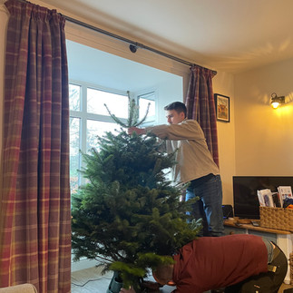 man decorating Christmas tree