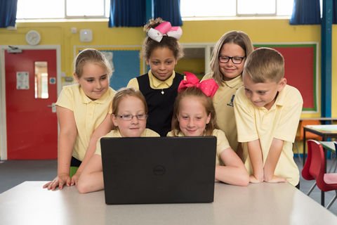 Students gathered around laptop, learning together at miltonprimaryschool