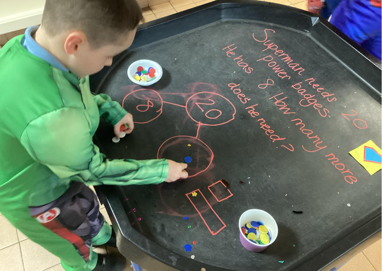 Boy solving a math problem: Superman needs 20 power badges. Year 2 Beaufort Hill