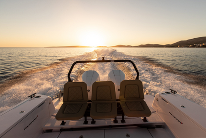 Speedboat cruising the sea during sunset