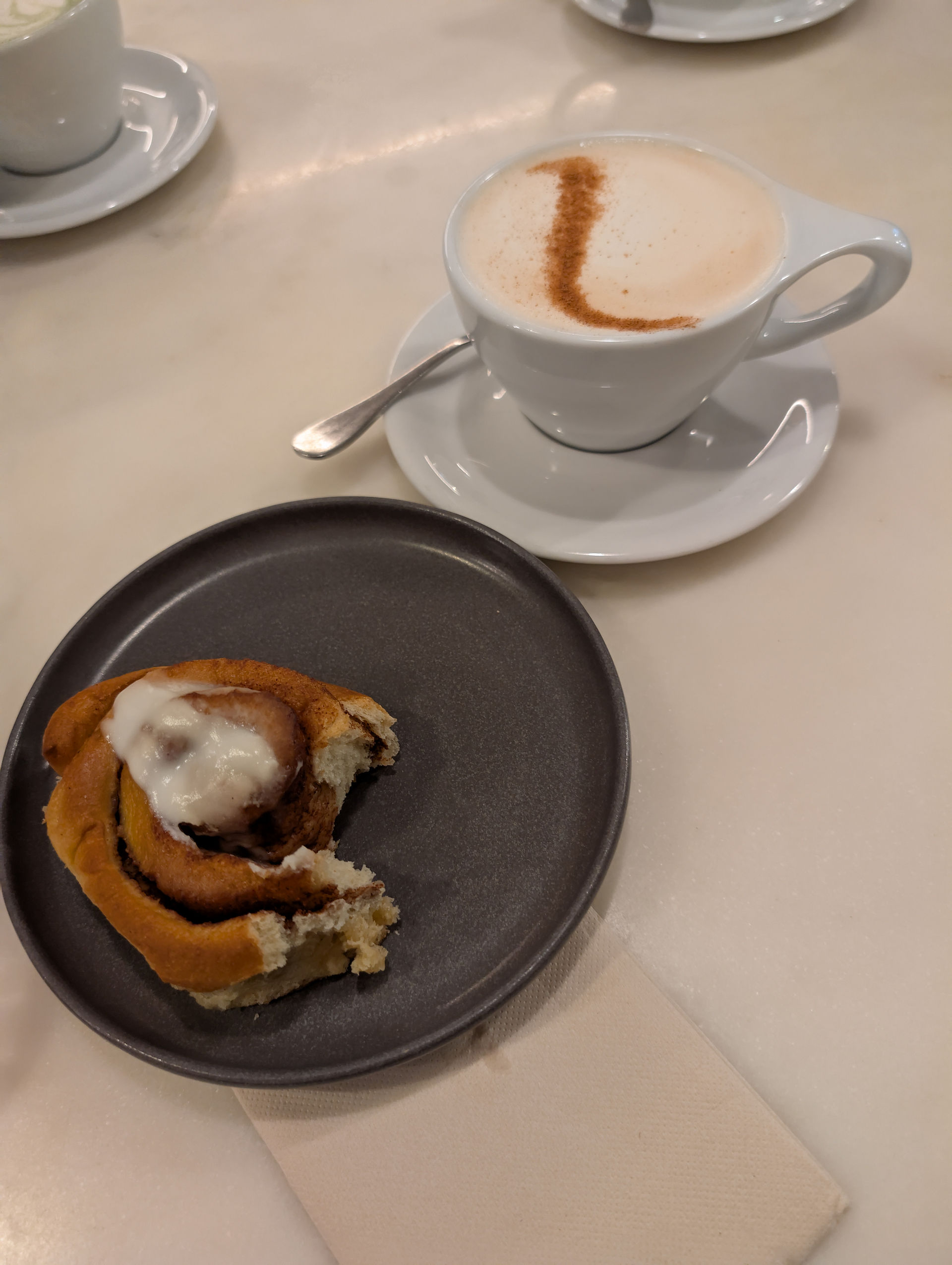 yummy cinnamon bun with icing served with a chai latte