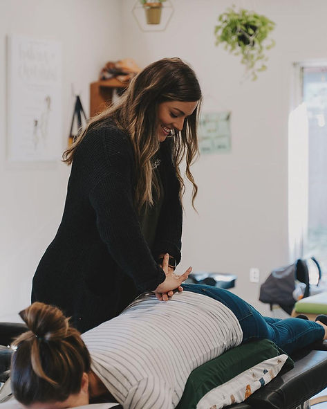 Chiropractor providing a gentle lower back adjustment to a pregnant patient with sciatica in Huntersville, NC.