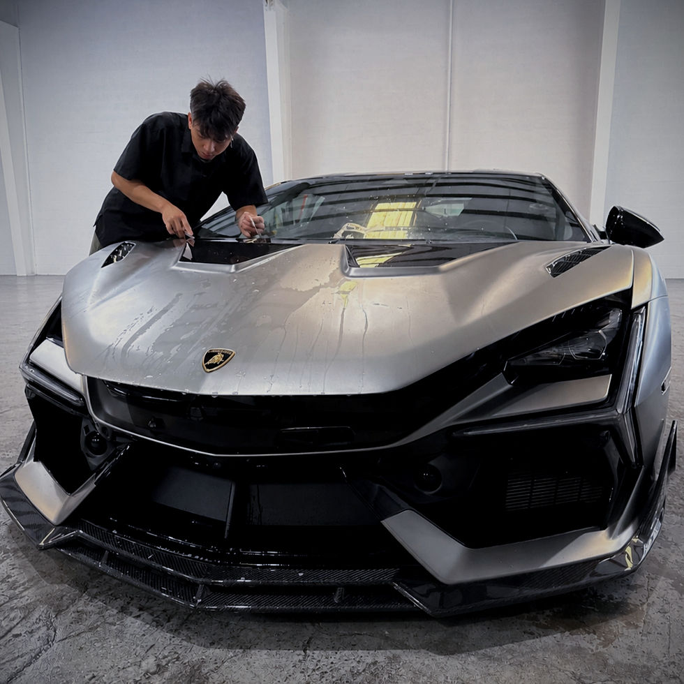 PPF installer working on a silver lamborghini revuelto