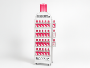 Présentoir sur mesure en forme de bouteille Bioderma avec cinq niveaux de flacons d’eau micellaire rose