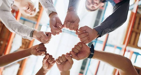 team gather around with group fist bump