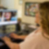 Janet Garcia, LCSW, smiling while working at her computer in her Palm City, Florida therapy office.