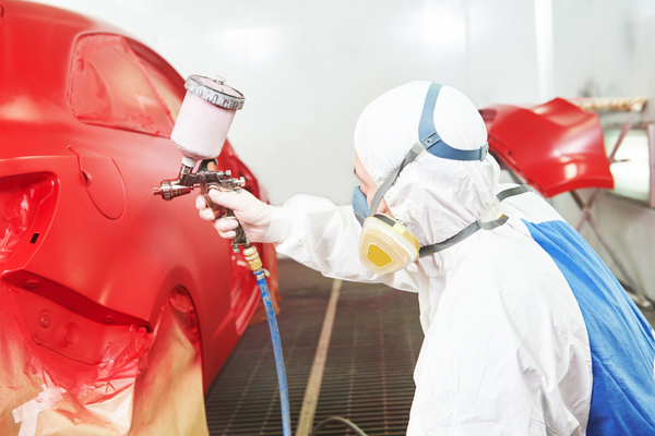 Technician painting a car for an auto collision repair estimate