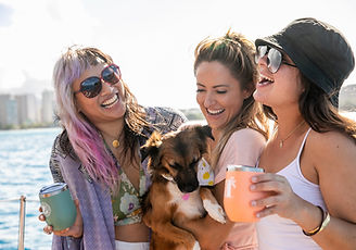 Three girls and a dog enjoying morning cofee on vida mia in Honolulu Hawaii