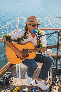 Musician playing guitar for sunset dinner cruise on the vida mia