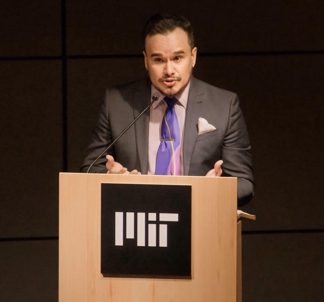 Guadalupe Hayes-Mota speaking at a podium at MIT