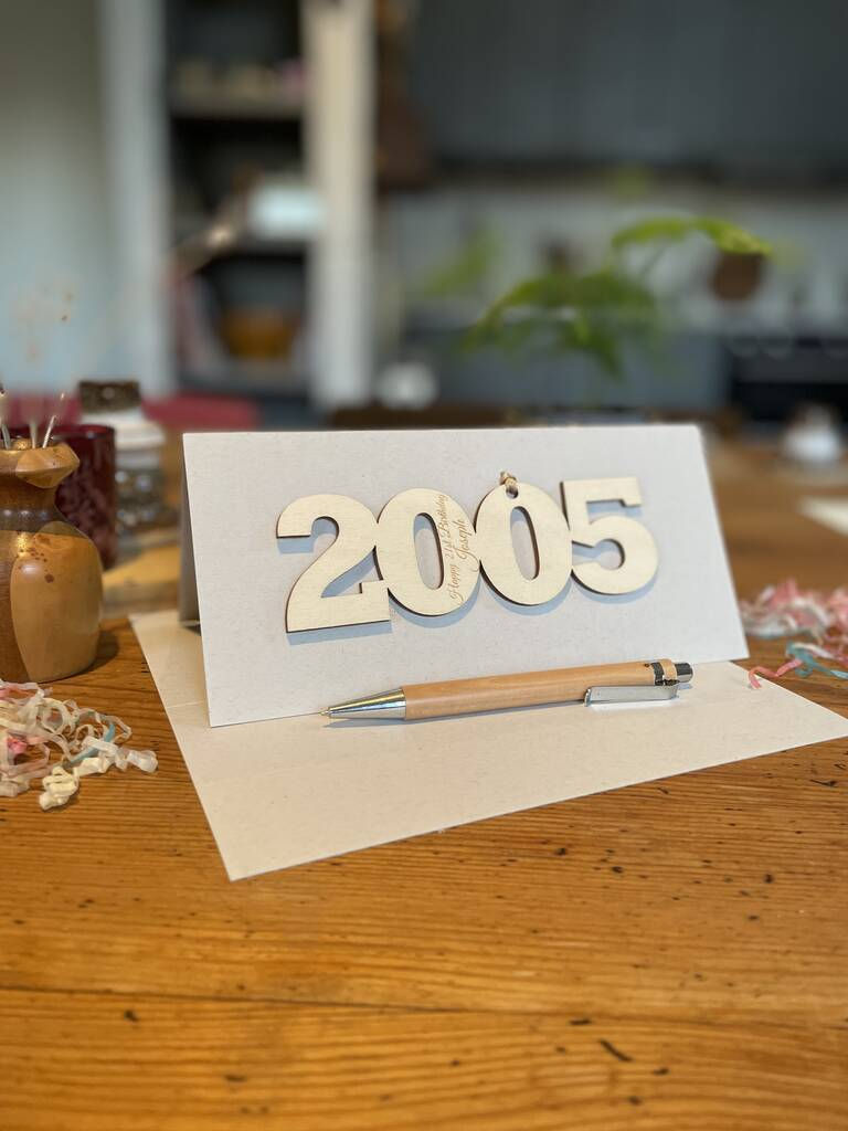 Thumbnail: 2005 21st birthday wooden motif attached to a cream craft card