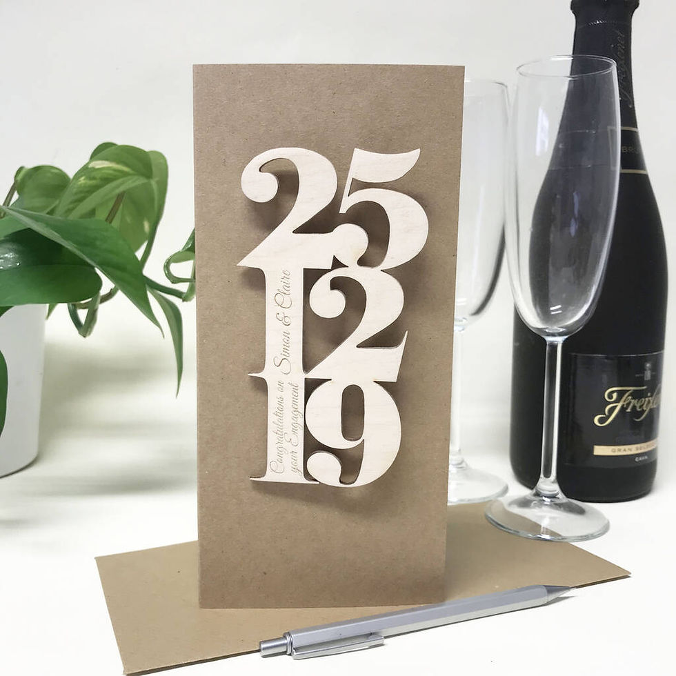 Thumbnail: wooden numbers251219 engraved with engagement date attached to a brown card