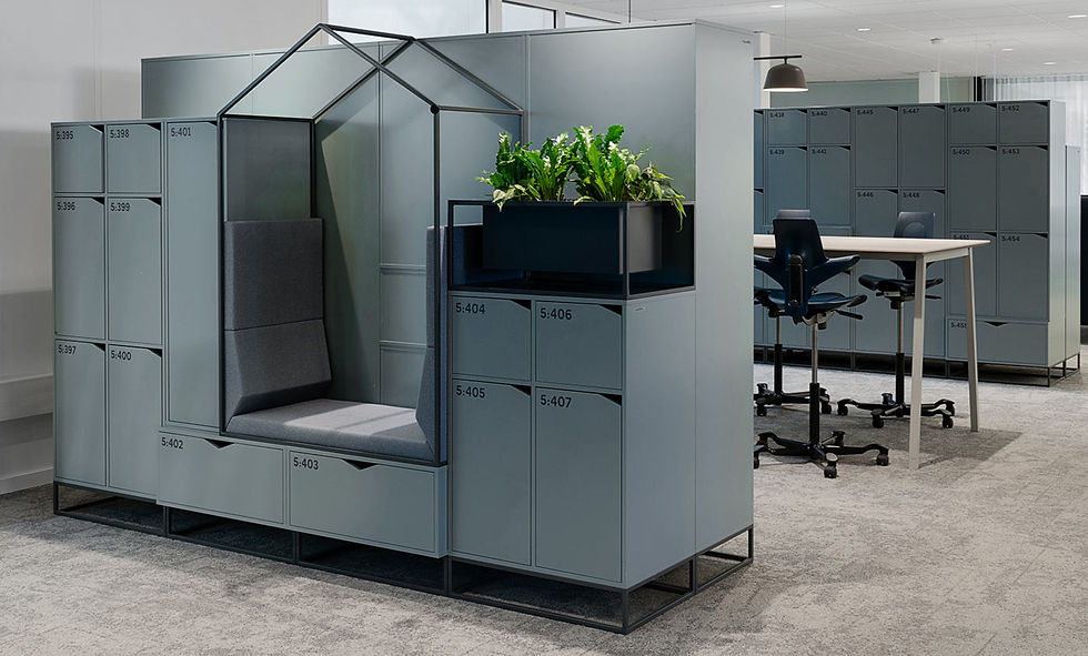 Modern office with gray lockers, a seating nook, and plants. High desk with chairs in the background; text includes numbers like 5:395. Neutral tones.