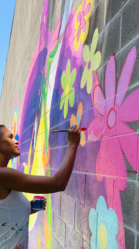 Artist muralist Jaya King painting flower mural in Sacramento.