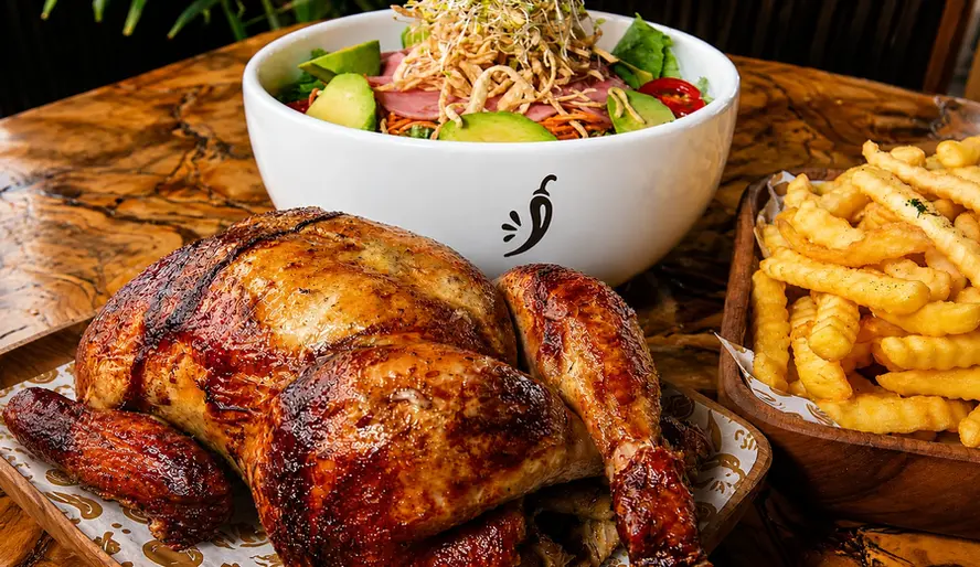 Pollo a la brasa entero con ensalada, papas fritas y salsa peruana
