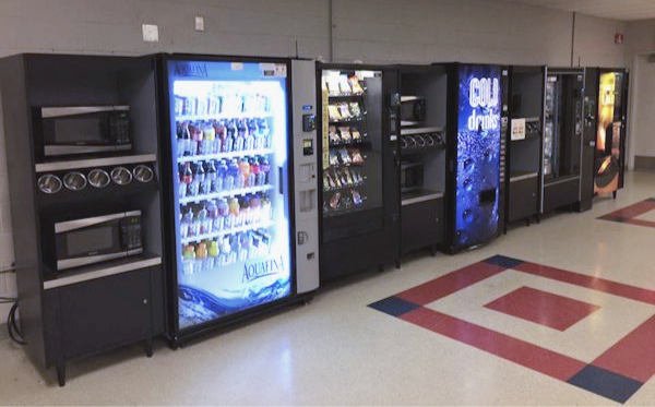Breakroom including vending machines and All State Manufacturing condiment/microwave organizer stands.