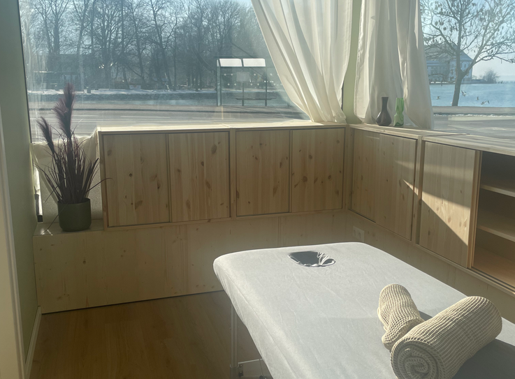 Behandlungsraum mit Massageliege im Studio KLEINE AUSZEIT in Seewalchen am Attersee, geeignet für Energiearbeit und Massage.