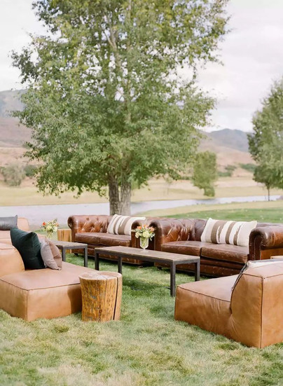 Outdoor wedding lounge seating with leather sofas and mountain views at exclusive-use private estate venue