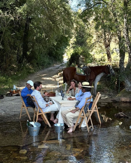 Corporate team enjoying outdoor alfresco dining in a natural creek setting with horses – unique exclusive-use retreat experience at Georgian countryside property