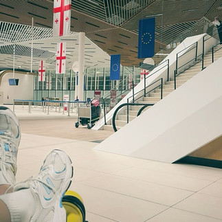 Tbilisi International Airport terminal with Georgian flag – direct flights from European hubs make Georgia accessible for corporate retreat travel in 2026