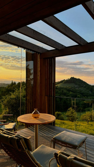 Modern glass terrace with panoramic vineyard views at sunset – exclusive-use Georgian wine estate retreat venue in Kakheti