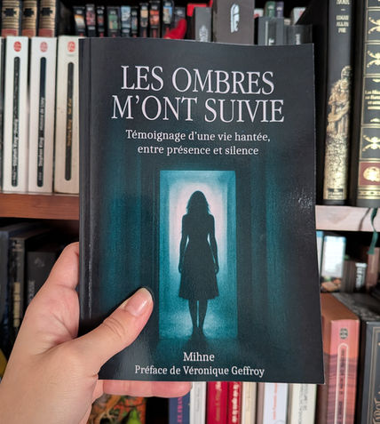 Couverture du livre Les Ombres M’ont Suivie tenue devant une étagère de livres