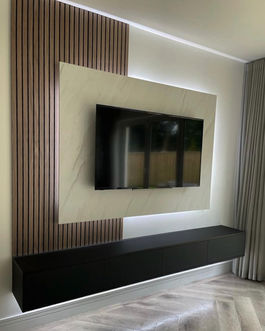 A modern TV mounted on a wall, showcasing a sleek design for a media wall setup