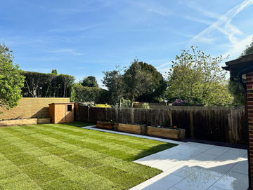 Garden with mowed grass, patio and wooden flower beds