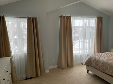 Grey-green bedroom with a high pitched ceiling and professionally painted walls featuring a smooth modern finish.