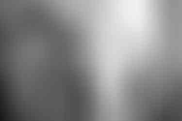 Moment de calme pendant les préparatifs du marié dans la Loire, lumière naturelle entrant par la fenêtre.