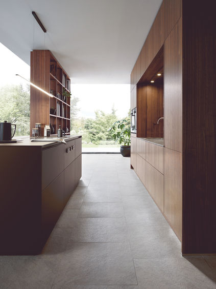 Galley view of Next125 luxury German kitchen with walnut units and Fenix Mocha island.