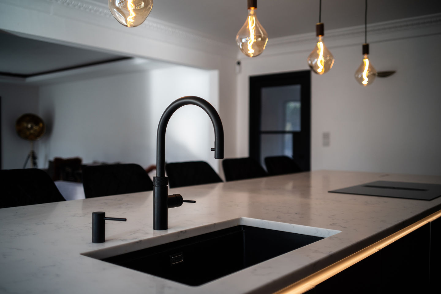 Next125 kitchen island with black Quooker Flex tap, Kuppersbusch hob, and white quartz top, designed by Scott Marks in North East UK.