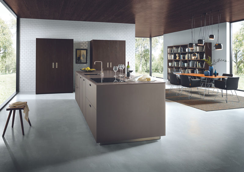 Next125 luxury kitchen with a platinum metallic matte glass island, two 1300mm dark tobacco oak pocket doors, and polished concrete floor in North East UK. 