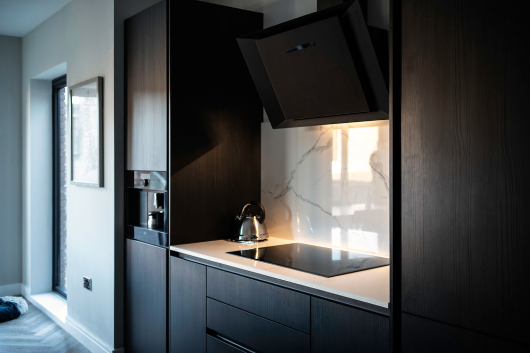 Next125 kitchen in Wynyard Park, Billingham, featuring a black AEG angled extractor above the hob and integrated bean-to-cup coffee machine.  