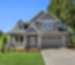 Beautiful new home exterior with two car garage and covered porch on sunny day.jpg