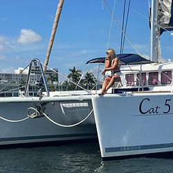 Cat 5 catamaran boat bow view with female guest seated at bow chairs in Fort Lauderdale marina, catamaran yacht rental