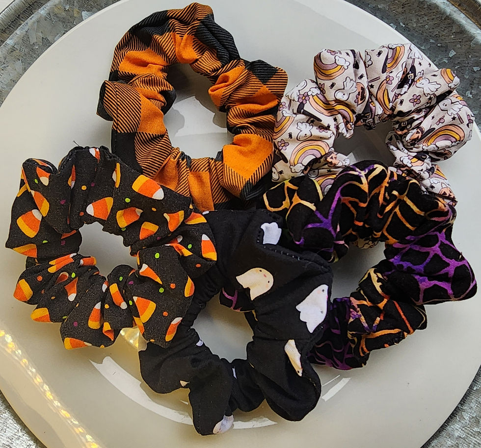Set of handmade Halloween scrunchies with candy corn, ghosts, pumpkins, and cobweb prints.