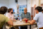 Four men at a table smiling and talking at a Investor Networking Event.