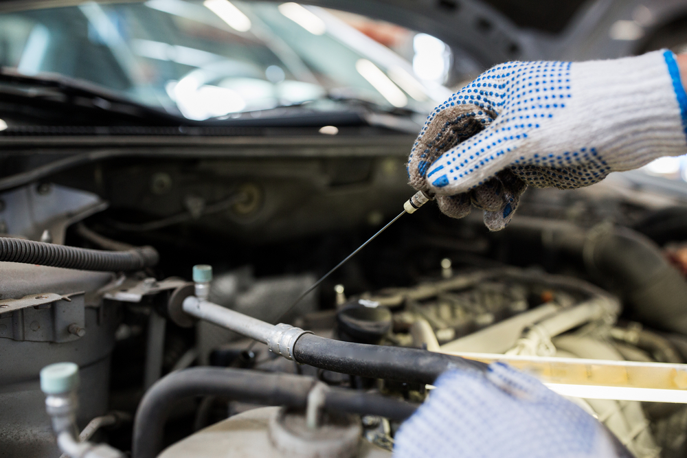 Technician checking engine oil