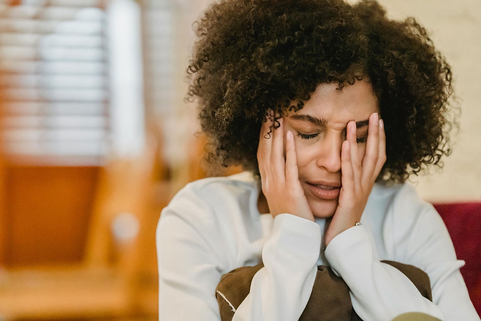 Woman holding her face in her hands in distress.