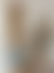 Wood cabinets and a white range hood in a kitchen under renovation. Counters covered with paper, blue tape visible. Tile backsplash.