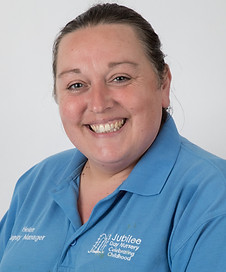 Smiling woman in blue Jubilee Day Nursery polo shirt with logo and her name, Helen, displayed.