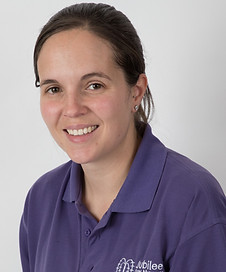 Smiling woman in purple Jubilee Day Nursery polo shirt with logo and her name, Jamie-Lee, displayed.