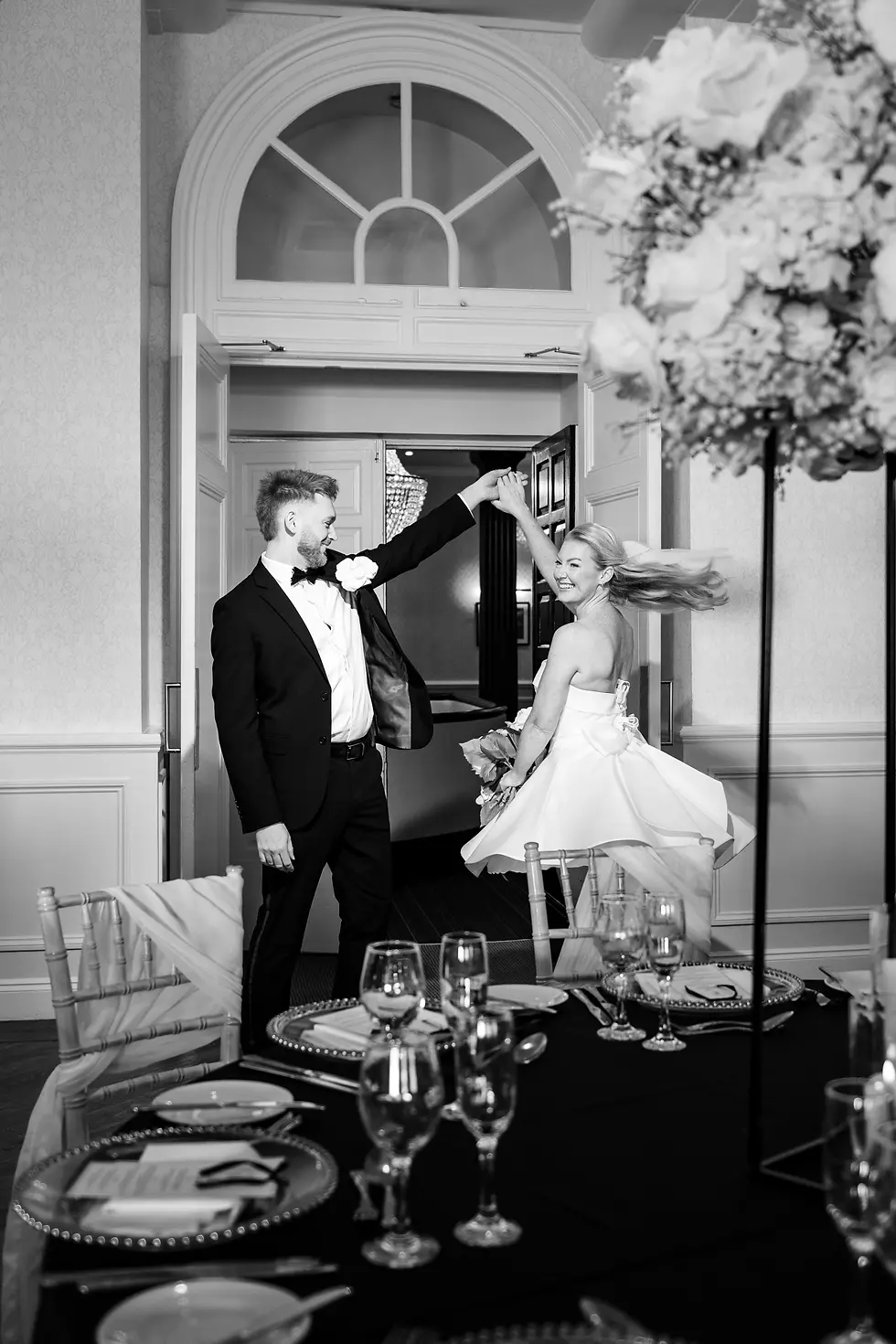 The bride spins through the doorway while the groom leads her into the beautifully dressed reception room at the Hythe Imperial.