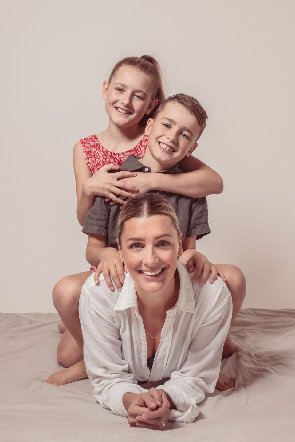 Family pile-up portrait of mum and two children in Kent studio