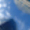 modern skyscrapers with windows, seen from the ground toward a blue sky with some white cl