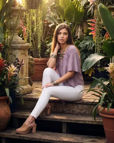 Model sitting on steps in an outdoor setting