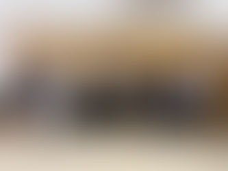 A group of expectant first time parents attend a Hello Baby antenatal class in Bushey. They are posing for a picture, standing in from of a wooden wall.